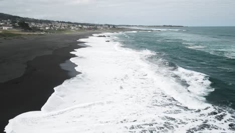 Panoramic-aerial-view-of-the-waves-in-Pichilemu,-Chile-on-a-cloudy-day