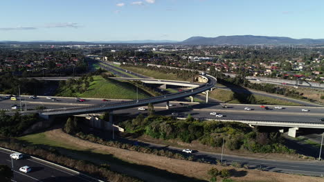 Slow-drone-tracking-and-sliding-around-major-highway-interchange-above-suburb-sprawl-below