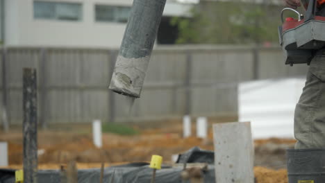 CLOSE-UP-Cement-Pump-Hose-Pours-Out-Concrete-Onto-Property-Slab