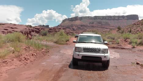 White-Range-Rover-truck-drives-through-shallow-river-crossing,-Utah