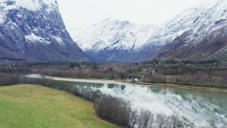 Carretera-Asfaltada-Junto-Al-Agua-Del-Lago-A-Los-Pies-De-La-Montaña-Trollveggen-En-El-Condado-De-More-Og-Romsdal,-Noruega