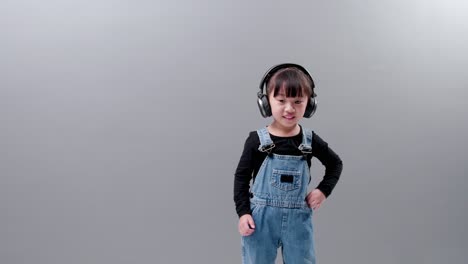 Kleines-Asiatisches-Mädchen-Mit-Kopfhörern,-Das-Musik-Hört-Und-Im-Studio-Tanzt