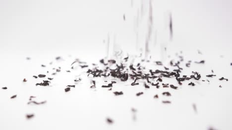Tea-Granules-Pouring-Down-On-White-Background---close-up,-slow-motion