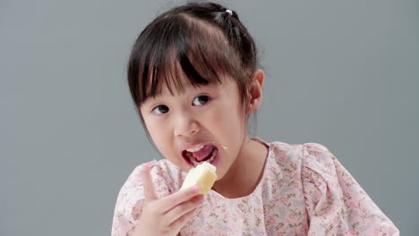 Nahaufnahme-Eines-Kleinen-Asiatischen-Mädchens,-Das-Sich-Auf-Das-Essen-Konzentriert,-Lächelt-Und-Knusprigen-Buttertoast-Glücklich-Zu-Hause-Isst