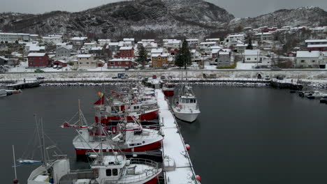 Fishing-Boats-In-The-Harbour-During-Winter-In-Skjervoy,-Troms,-Norway---aerial-drone-shot