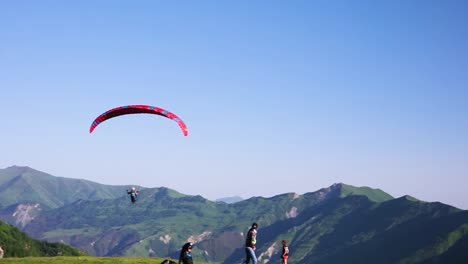 Paraglider-Flying-Above-Valley-With-Hill-Landscape-Of-Kazbegi-In-The-Distanct