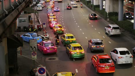 Yellow-Taxis-line-up-to-pick-up-passengers-in-front-of-a-shopping-mall-in-the-evening-after-work-and-the-situation-of-the-Covid-19-epidemic-in-Bangkok,-Thailand