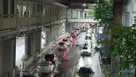 Gente-Caminando-En-La-Pasarela-Sobre-El-Tráfico-A-Través-De-Intersecciones-Concurridas-En-Hora-Punta-En-Bangkok