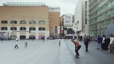 Barcelona---Plaça-Dels-Àngels,-Außerhalb-Des-Museums-Für-Zeitgenössische-Kunst-Mit-Skateboarder,-Der-Tricks-Macht