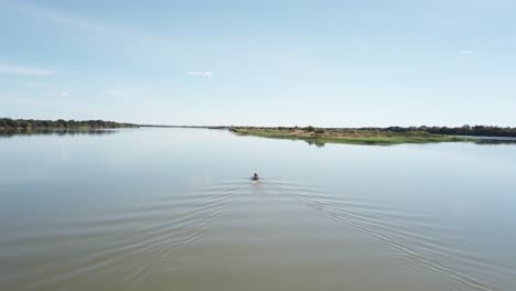 Wide-aerial-shot-following-a-small-fishing-boat-on-the-Sao-Francisco-River-in-rural-Brazil