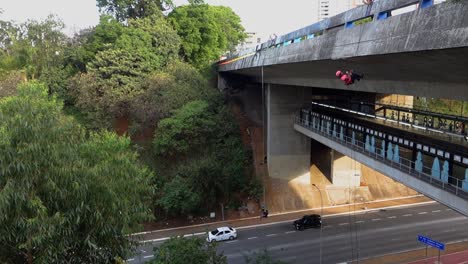 brave-girl-rappeling-down-on-viaduct-on-Sumare-Avenue,-in-Sao-Paulo-city