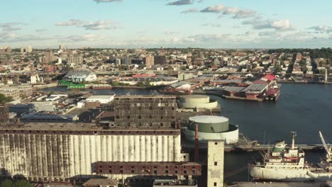 Stationary-aerial-shot-of-the-massive-abandoned-grain-terminal-and-an-rusty-ship-nearby-in-Brooklyn-New-York