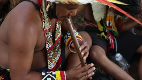 En-Una-Protesta-Por-La-Selva-Amazónica,-Un-Indígena-Toca-Una-Flauta-Tribal-Tradicional