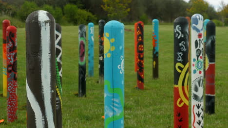 Colorful-Aboriginal-Artwork-Painted-On-Wooden-Totem-Poles