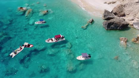 The-beautiful-beach-at-the-Cape-Mizithres-with-turquoise-sea-and-boats-enjoying-the-summer-scenery,-Keri,-Zakynthos-island,-Greece