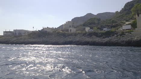 Sicilian-Levanzo-island-and-seafront-scenic-cemetery-as-seen-from-boat-sailing,-Sicily-in-Italy