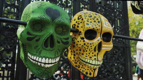 A-pair-of-green-and-yellow-calavera-sugar-skulls-on-display-celebrating-the-Day-of-The-Dead-in-bosque-de-chapultepec,-Mexico-City