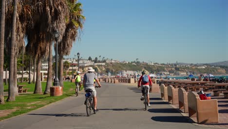 People-riding-bikes-on-a-path-at-Doheny-Beach-in-Dana-Point,-California
