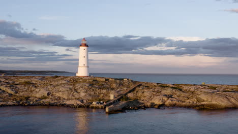 Lille-Torungen-Lighthouse-By-Sea-Against-Cloudy-Sky-During-Sunset-In-Arendal,-Norway---aerial-drone-shot