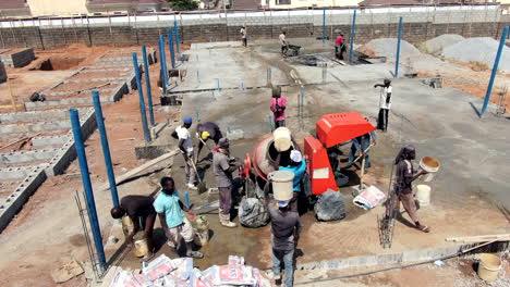 Mixing-and-pouring-cement-for-the-foundation-of-a-building-in-the-Lokogoma-suburb-of-Abuja---carrying-buckets-on-heads