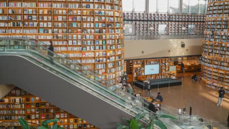 The-Starfield-Library-in-the-COEX-Mall-in-Seoul,-South-Korea-and-foot-traffic---time-lapse-of-the-escalator-and-entrance