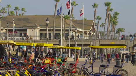 A-bunch-of-pedal-carts-and-with-people-moving-about-in-Huntington-Beach,-California