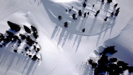Vista-Aérea-De-Personas-Esquiando-Y-Haciendo-Snowboard-En-La-Colina,-Estación-De-Esquí