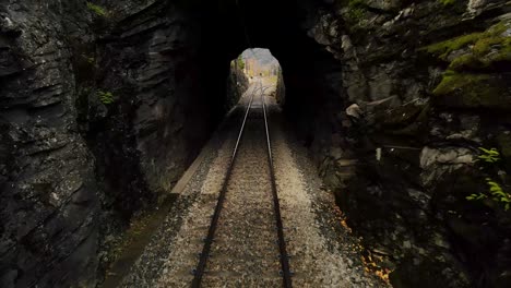 Paso-Lento-A-Través-De-Un-Túnel-Ferroviario,-Con-Las-Vías-Separándose-A-La-Salida