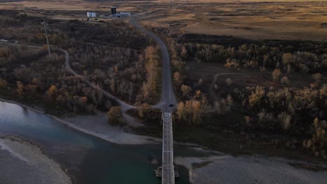 Aerial-footage-of-an-old-truss-bridge-over-old-man-river-in-Alberta,-Canada-during-autumn