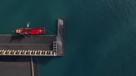Red-cargo-ship-anchored-at-quay-of-Tazacorte-harbor-in-La-Palma-island