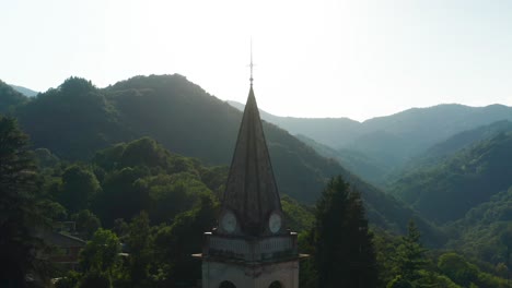 Lufttransportwagen-Um-Die-Spitze-Der-Pfarrkirche-In-Einem-Bewaldeten-Hügel-In-Arola,-Italien