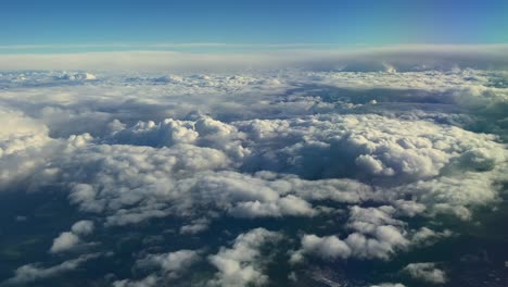 Vista-De-Pájaro-Sobre-Nubes-Majestuosas-Desde-La-Ventana-Del-Avión