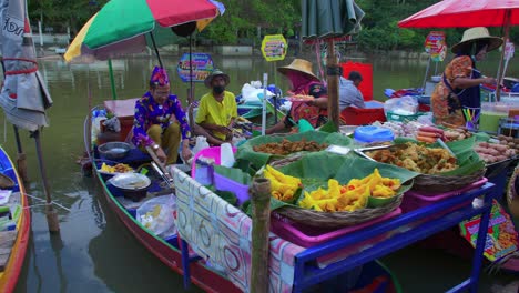 Malerische-Landschaft-Von-Thailändern,-Die-Straßenessen-Von-Einem-Kleinen-Hölzernen-Rustikalen-Boot-Verkaufen