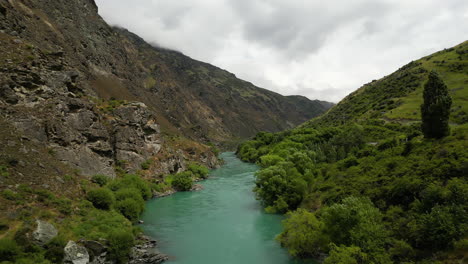 Valle-De-Montaña-Y-Río-Azul-Que-Fluye-Dentro-En-Nueva-Zelanda,-Vista-Aérea-De-Drones