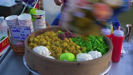 Nahaufnahme-Eines-Großen-Behälters-Mit-Thailändischem-Gemüse,-Das-Der-Verkäufer-In-Plastiktüten-An-Den-Kunden-Liefert