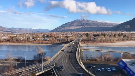 Pan-Up-Shot-of-Cars-Driving-Over-the-Overlanders-Bridge-in-Kamloops,-British-Columbia-on-a-Sunny-Morning