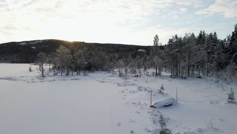 Winterlandschaft-Mit-Einem-Schneebedeckten-Boot-Am-Ufer-Eines-Zugefrorenen-Sees-In-Den-Bergen