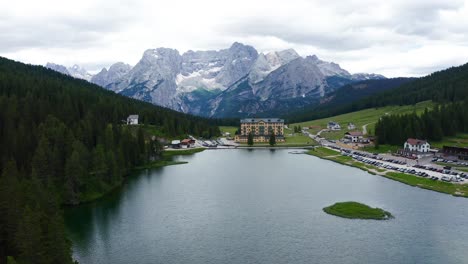 Aerial-Dolly-Over-Lake-Misurina-Towards-Istituto-Pio-Xii-Rehabilitation-Centre-With-Dolomite-Mountains-In-The-Background
