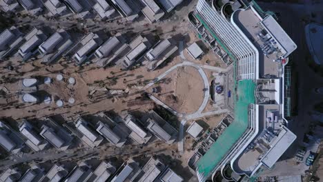 Beach-resort-or-residential-development-under-construction-from-top-down-aerial-view-including-main-building,-villas,-swimming-pool,-beach-and-ocean-on-sunny-day