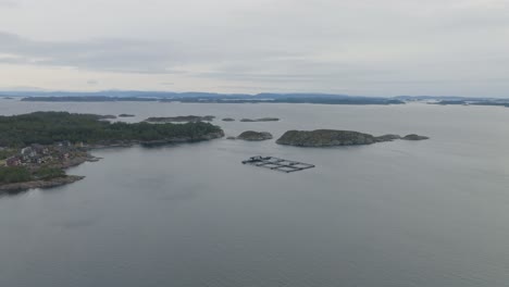 Norway-fish-farm-in-coastal-waters-south-of-Steinsland-in-Sotra-island---Distant-aerial-view-of-facility-and-surrounding-coastal-waters