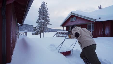 Man-Using-Sleigh-Shovel-To-Remove-Deep-Snow-In-Indre-Fosen,-Norway---wide