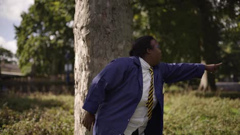Black-Girl-with-Down-Syndrome-Pointing-In-School-Uniform-under-a-tree