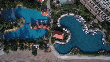 Grand-Hotel-Ho-Tram,-Vietnam-top-down-aerial-view-featuring-swimming-pool-on-a-sunny-morning