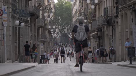 Gente-Caminando-Y-Andando-En-Bicicleta-Por-Una-Calle-Concurrida-Y-Concurrida-En-La-Ciudad-De-Barcelona