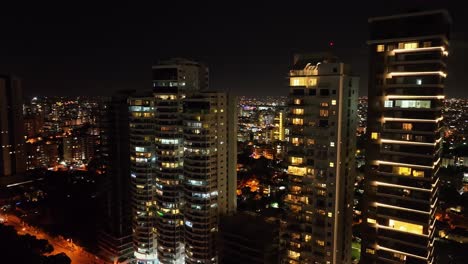 Toma-De-órbita-Aérea-De-Bloques-De-Apartamentos-De-Iluminación-En-La-Avenida-Anacaona-En-La-Noche-En-Santo-Domingo
