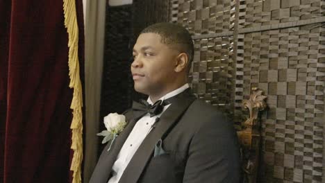Groom-sitting-as-he-is-photographed-on-his-wedding-day