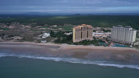 Aerial-view-of-Grand-Hotel-Ho-Tram,-Vietnam-featuring-buildings,-swimming-pool-and-beach