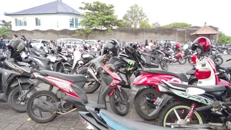 Estacionamiento-De-Motocicletas-Y-Scooters-Antiguos-En-La-Playa-De-Purnama-En-Bali,-Indonesia,-Motocicletas-Coloridas-Y-Cascos