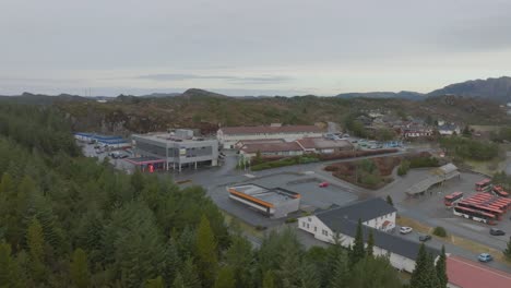 Approaching-sundsenteret-small-shopping-mall-in-Skogsvag-in-the-island-of-Sotra-Norway---Aerial