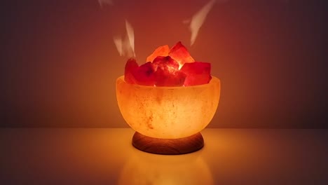 Himalayan-salt-lamp-glowing-on-а-table-against-dark-background,-zoom-in